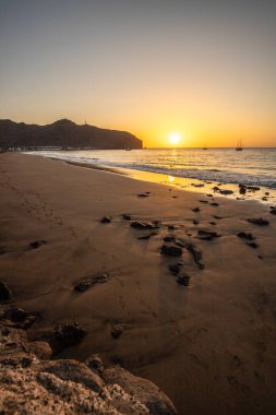 Sabah kumsalda. Güneşin doğuşunda deniz manzarası. Koyun kıyı şeridi, hafif bir kum fırtınası sırasında siyah kumlar, bir Calima. Gran Tarajal, Kanarya Adaları, İspanya