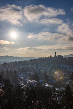 Bakış açısı ve manzara akşam üstü gün batımında çekiliyor. Kale manzarasında soğuk hava ve hafif kar. Şatoya ve kışın Frankfurt Knigstein, Taunus, Hesse, Almanya yakınlarındaki bir köye bakın.