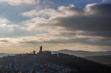 Viewpoint and landscape shot in the evening at sunset. Cold weather and light snow at the castle view. View to the castle and over a village in winter near Frankfurt Knigstein, Taunus, Hesse, Germany clipart