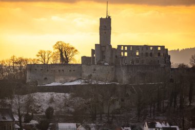 Viewpoint and landscape shot in the evening at sunset. Cold weather and light snow at the castle view. View to the castle and over a village in winter near Frankfurt Knigstein, Taunus, Hesse, Germany clipart