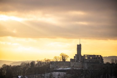 Bakış açısı ve manzara akşam üstü gün batımında çekiliyor. Kale manzarasında soğuk hava ve hafif kar. Şatoya ve kışın Frankfurt Knigstein, Taunus, Hesse, Almanya yakınlarındaki bir köye bakın.