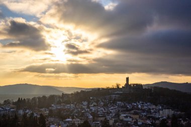 Viewpoint and landscape shot in the evening at sunset. Cold weather and light snow at the castle view. View to the castle and over a village in winter near Frankfurt Knigstein, Taunus, Hesse, Germany clipart