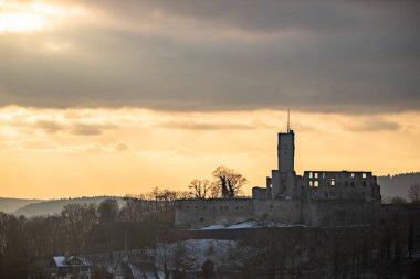 Viewpoint and landscape shot in the evening at sunset. Cold weather and light snow at the castle view. View to the castle and over a village in winter near Frankfurt Knigstein, Taunus, Hesse, Germany clipart