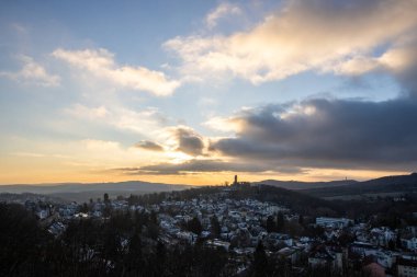 Bakış açısı ve manzara akşam üstü gün batımında çekiliyor. Kale manzarasında soğuk hava ve hafif kar. Şatoya ve kışın Frankfurt Knigstein, Taunus, Hesse, Almanya yakınlarındaki bir köye bakın.