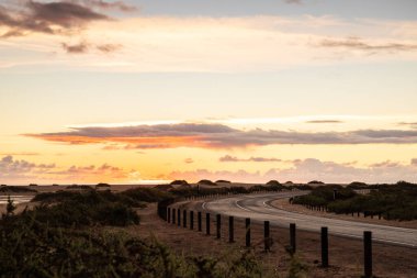 Kumulların arasında bir yolda güzel bir sabah. Bulutlu bir yolda gün doğumu. Corralejo Ulusal Parkı, Kanarya Adaları, İspanya