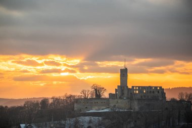 Knigstein Şatosu günbatımında harabeye döner. Bir köy manzaralı, kışın harabe haline bakan arka planda gün batımını görebilirsiniz. Knigstein im Taunus 'un manzara fotoğrafı, Hesse, Almanya