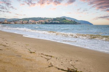 Arka planda tepeler olan sahil ve deniz güney İtalya 'da tatil köyü olan körfez ve kıyı.