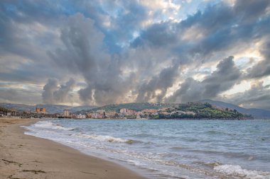 Arka planda tepeler olan sahil ve deniz güney İtalya 'da tatil köyü olan körfez ve kıyı.