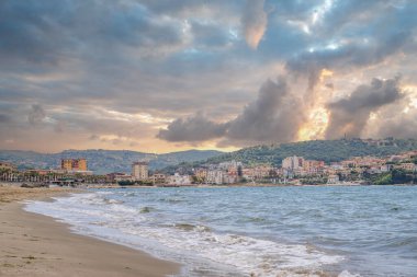 Arka planda tepeler olan sahil ve deniz güney İtalya 'da tatil köyü olan körfez ve kıyı.