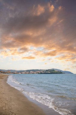 Arka planda tepeler olan sahil ve deniz güney İtalya 'da tatil köyü olan körfez ve kıyı.