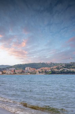 Arka planda tepeler olan sahil ve deniz güney İtalya 'da tatil köyü olan körfez ve kıyı.