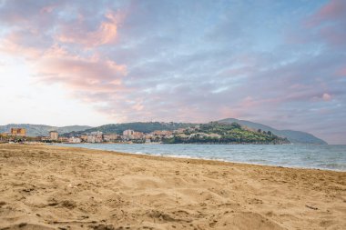 Arka planda tepeler olan sahil ve deniz güney İtalya 'da tatil köyü olan körfez ve kıyı.