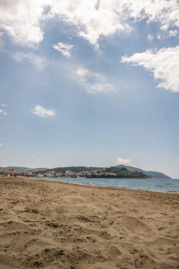 Arka planda tepeler olan sahil ve deniz güney İtalya 'da tatil köyü olan körfez ve kıyı.