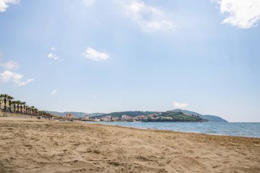 Arka planda tepeler olan sahil ve deniz güney İtalya 'da tatil köyü olan körfez ve kıyı.