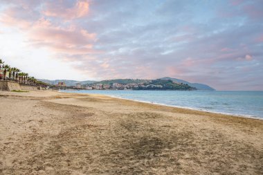 Arka planda tepeler olan sahil ve deniz güney İtalya 'da tatil köyü olan körfez ve kıyı.