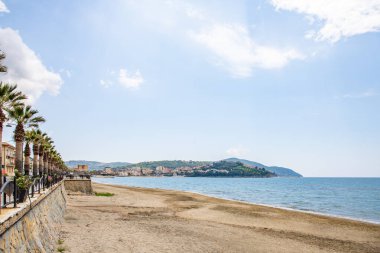 Arka planda tepeler olan sahil ve deniz güney İtalya 'da tatil köyü olan körfez ve kıyı.
