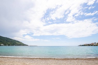Arka planda tepeler olan sahil ve deniz güney İtalya 'da tatil köyü olan körfez ve kıyı.