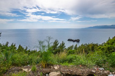 Kıyı manzarası fotoğrafı. Deniz boyunca uzanan ve çarpıcı yeşil Akdeniz manzarası boyunca uzanan bir yoldan manzara. Salerno, İtalya kıyıları