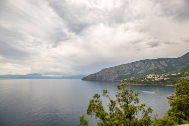 Kıyı manzarası fotoğrafı. Deniz boyunca uzanan ve çarpıcı yeşil Akdeniz manzarası boyunca uzanan bir yoldan manzara. Salerno, İtalya kıyıları