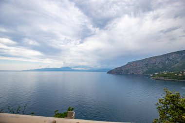 Kıyı manzarası fotoğrafı. Deniz boyunca uzanan ve çarpıcı yeşil Akdeniz manzarası boyunca uzanan bir yoldan manzara. Salerno, İtalya kıyıları
