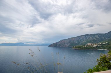 Kıyı manzarası fotoğrafı. Deniz boyunca uzanan ve çarpıcı yeşil Akdeniz manzarası boyunca uzanan bir yoldan manzara. Salerno, İtalya kıyıları