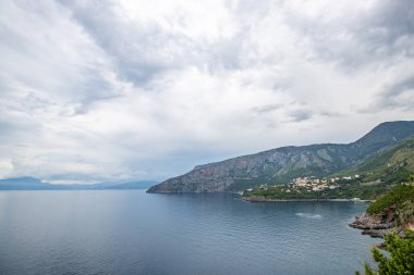 Kıyı manzarası fotoğrafı. Deniz boyunca uzanan ve çarpıcı yeşil Akdeniz manzarası boyunca uzanan bir yoldan manzara. Salerno, İtalya kıyıları