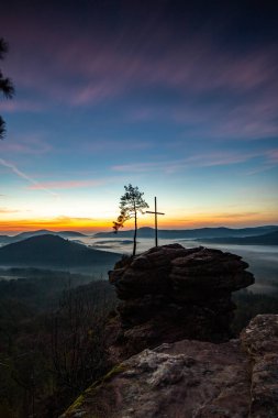Zirve, ormanın ortasında bir kumtaşı kayası üzerinde kesişiyor. Sis kaplı bir ormanın üzerindeki muhteşem manzaralı manzara. Almanya 'nın Derebeyi Ormanı' nda Gün Doğumu