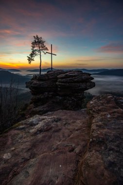 Zirve, ormanın ortasında bir kumtaşı kayası üzerinde kesişiyor. Sis kaplı bir ormanın üzerindeki muhteşem manzaralı manzara. Almanya 'nın Derebeyi Ormanı' nda Gün Doğumu