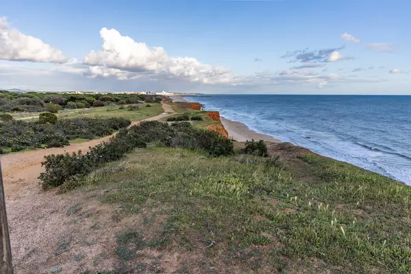 Atlantik Okyanusu 'nda çarpıcı oluşumları olan kayalıklar. Manzara çekiminde sıcak gün batımı. Sahilde ve denizde çarpıcı oluşumlara sahip kızıl kayalıklar, Praia da Falsia, Algarve, Portekiz