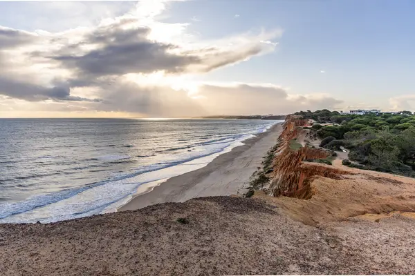 Atlantik Okyanusu 'nda çarpıcı oluşumları olan kayalıklar. Manzara çekiminde sıcak gün batımı. Sahilde ve denizde çarpıcı oluşumlara sahip kızıl kayalıklar, Praia da Falsia, Algarve, Portekiz