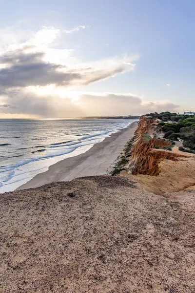 Atlantik Okyanusu 'nda çarpıcı oluşumları olan kayalıklar. Manzara çekiminde sıcak gün batımı. Sahilde ve denizde çarpıcı oluşumlara sahip kızıl kayalıklar, Praia da Falsia, Algarve, Portekiz