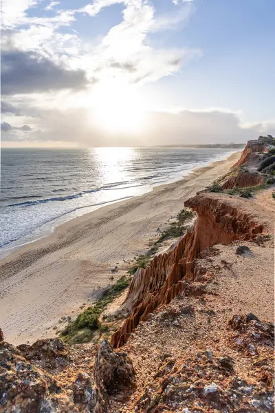 Atlantik Okyanusu 'nda çarpıcı oluşumları olan kayalıklar. Manzara çekiminde sıcak gün batımı. Sahilde ve denizde çarpıcı oluşumlara sahip kızıl kayalıklar, Praia da Falsia, Algarve, Portekiz