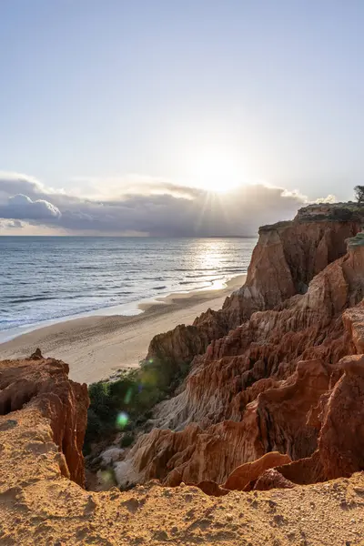 Atlantik Okyanusu 'nda çarpıcı oluşumları olan kayalıklar. Manzara çekiminde sıcak gün batımı. Sahilde ve denizde çarpıcı oluşumlara sahip kızıl kayalıklar, Praia da Falsia, Algarve, Portekiz