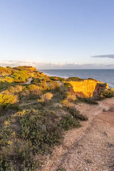 Atlantik Okyanusu 'nda çarpıcı oluşumları olan kayalıklar. Manzara çekiminde sıcak gün batımı. Sahilde ve denizde çarpıcı oluşumlara sahip kızıl kayalıklar, Praia da Falsia, Algarve, Portekiz