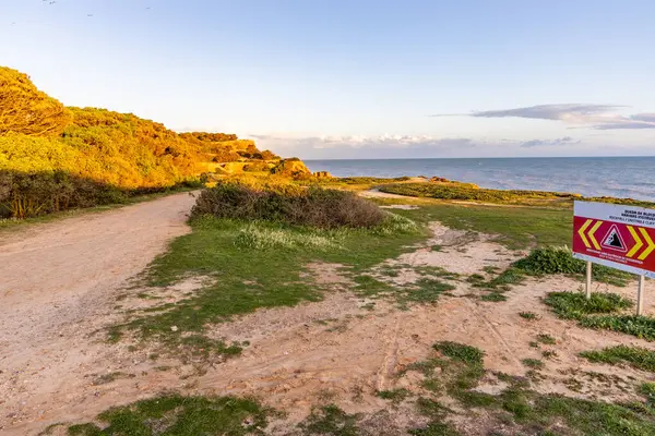 Atlantik Okyanusu 'nda çarpıcı oluşumları olan kayalıklar. Manzara çekiminde sıcak gün batımı. Sahilde ve denizde çarpıcı oluşumlara sahip kızıl kayalıklar, Praia da Falsia, Algarve, Portekiz