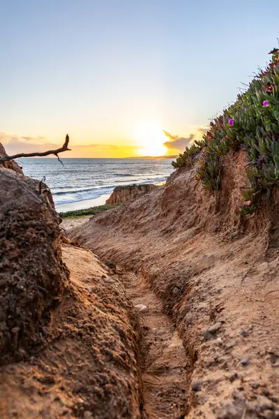 Bir çakıl taşı ve kumsalda inanılmaz kaya oluşumu. Kızıl topraklı kızıl kayalıklar ve kumlu sahilde inanılmaz oluşumlar. Praia da Falsia, sıcak güneş ışığıyla yıkanmış, Algarve, Portekiz