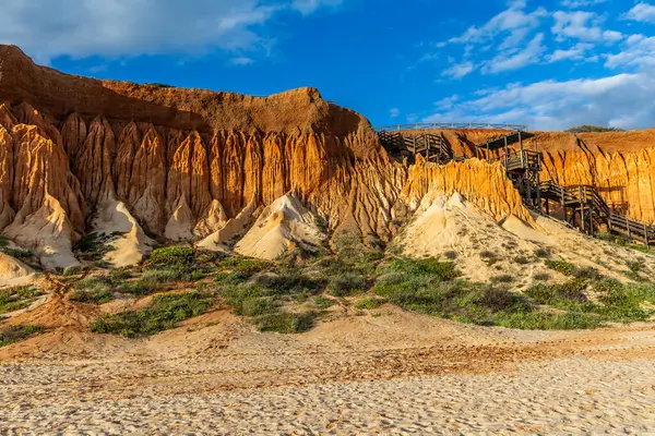 Bir çakıl taşı ve kumsalda inanılmaz kaya oluşumu. Kızıl topraklı kızıl kayalıklar ve kumlu sahilde inanılmaz oluşumlar. Praia da Falsia, sıcak güneş ışığıyla yıkanmış, Algarve, Portekiz