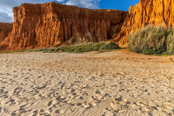 Bir çakıl taşı ve kumsalda inanılmaz kaya oluşumu. Kızıl topraklı kızıl kayalıklar ve kumlu sahilde inanılmaz oluşumlar. Praia da Falsia, sıcak güneş ışığıyla yıkanmış, Algarve, Portekiz