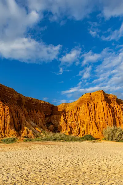 Bir çakıl taşı ve kumsalda inanılmaz kaya oluşumu. Kızıl topraklı kızıl kayalıklar ve kumlu sahilde inanılmaz oluşumlar. Praia da Falsia, sıcak güneş ışığıyla yıkanmış, Algarve, Portekiz