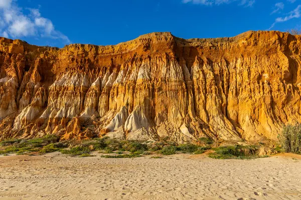 Bir çakıl taşı ve kumsalda inanılmaz kaya oluşumu. Kızıl topraklı kızıl kayalıklar ve kumlu sahilde inanılmaz oluşumlar. Praia da Falsia, sıcak güneş ışığıyla yıkanmış, Algarve, Portekiz