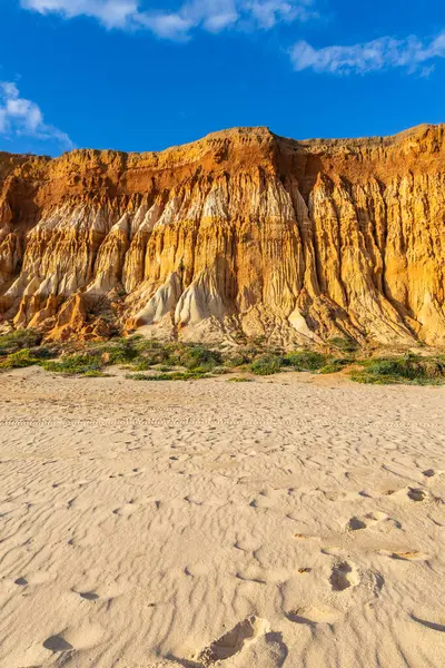 Bir çakıl taşı ve kumsalda inanılmaz kaya oluşumu. Kızıl topraklı kızıl kayalıklar ve kumlu sahilde inanılmaz oluşumlar. Praia da Falsia, sıcak güneş ışığıyla yıkanmış, Algarve, Portekiz