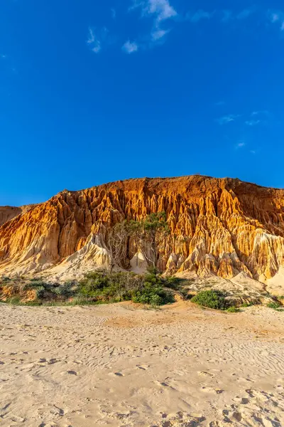Bir çakıl taşı ve kumsalda inanılmaz kaya oluşumu. Kızıl topraklı kızıl kayalıklar ve kumlu sahilde inanılmaz oluşumlar. Praia da Falsia, sıcak güneş ışığıyla yıkanmış, Algarve, Portekiz