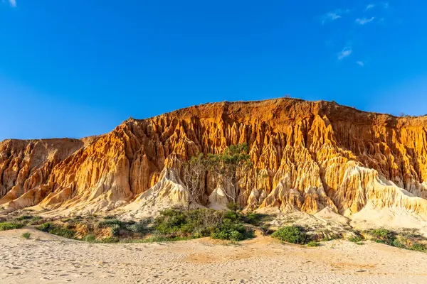 Bir çakıl taşı ve kumsalda inanılmaz kaya oluşumu. Kızıl topraklı kızıl kayalıklar ve kumlu sahilde inanılmaz oluşumlar. Praia da Falsia, sıcak güneş ışığıyla yıkanmış, Algarve, Portekiz