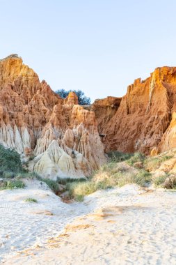 Bir çakıl taşı ve kumsalda inanılmaz kaya oluşumu. Kızıl topraklı kızıl kayalıklar ve kumlu sahilde inanılmaz oluşumlar. Praia da Falsia, sıcak güneş ışığıyla yıkanmış, Algarve, Portekiz