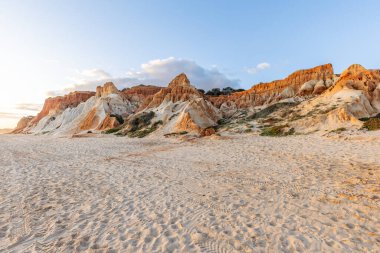 Bir çakıl taşı ve kumsalda inanılmaz kaya oluşumu. Kızıl topraklı kızıl kayalıklar ve kumlu sahilde inanılmaz oluşumlar. Praia da Falsia, sıcak güneş ışığıyla yıkanmış, Algarve, Portekiz
