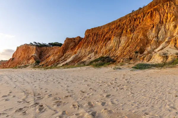 Bir çakıl taşı ve kumsalda inanılmaz kaya oluşumu. Kızıl topraklı kızıl kayalıklar ve kumlu sahilde inanılmaz oluşumlar. Praia da Falsia, sıcak güneş ışığıyla yıkanmış, Algarve, Portekiz