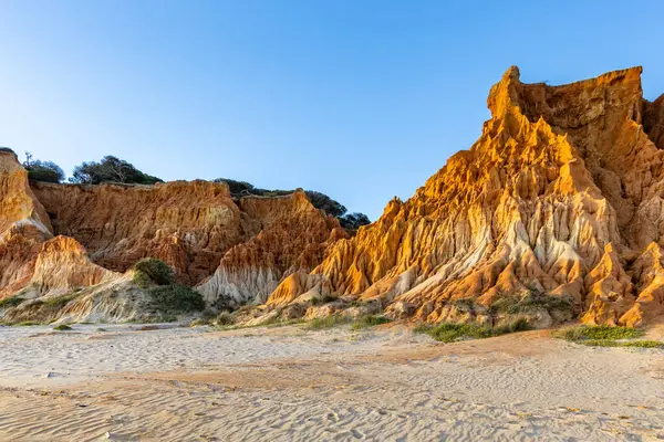 Bir çakıl taşı ve kumsalda inanılmaz kaya oluşumu. Kızıl topraklı kızıl kayalıklar ve kumlu sahilde inanılmaz oluşumlar. Praia da Falsia, sıcak güneş ışığıyla yıkanmış, Algarve, Portekiz