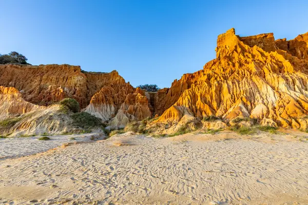 Bir çakıl taşı ve kumsalda inanılmaz kaya oluşumu. Kızıl topraklı kızıl kayalıklar ve kumlu sahilde inanılmaz oluşumlar. Praia da Falsia, sıcak güneş ışığıyla yıkanmış, Algarve, Portekiz