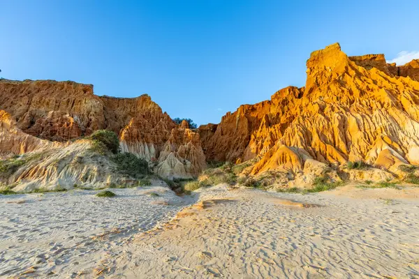 Bir çakıl taşı ve kumsalda inanılmaz kaya oluşumu. Kızıl topraklı kızıl kayalıklar ve kumlu sahilde inanılmaz oluşumlar. Praia da Falsia, sıcak güneş ışığıyla yıkanmış, Algarve, Portekiz