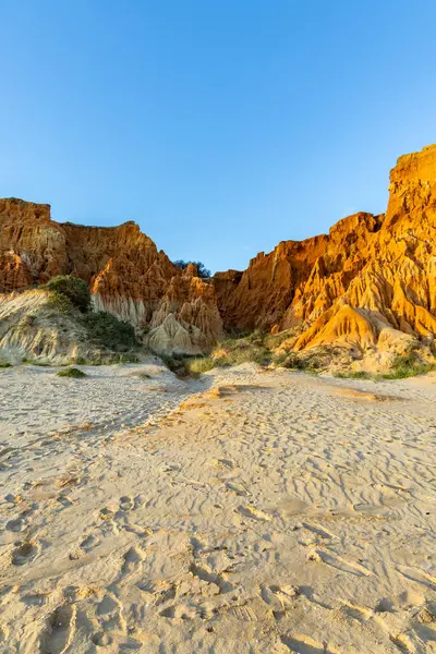 Bir çakıl taşı ve kumsalda inanılmaz kaya oluşumu. Kızıl topraklı kızıl kayalıklar ve kumlu sahilde inanılmaz oluşumlar. Praia da Falsia, sıcak güneş ışığıyla yıkanmış, Algarve, Portekiz